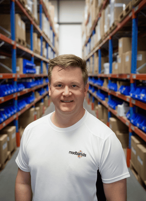Man wearing a white t-shirt with 'modbands' logo in a warehouse setting